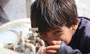 boy drinking water and smiling