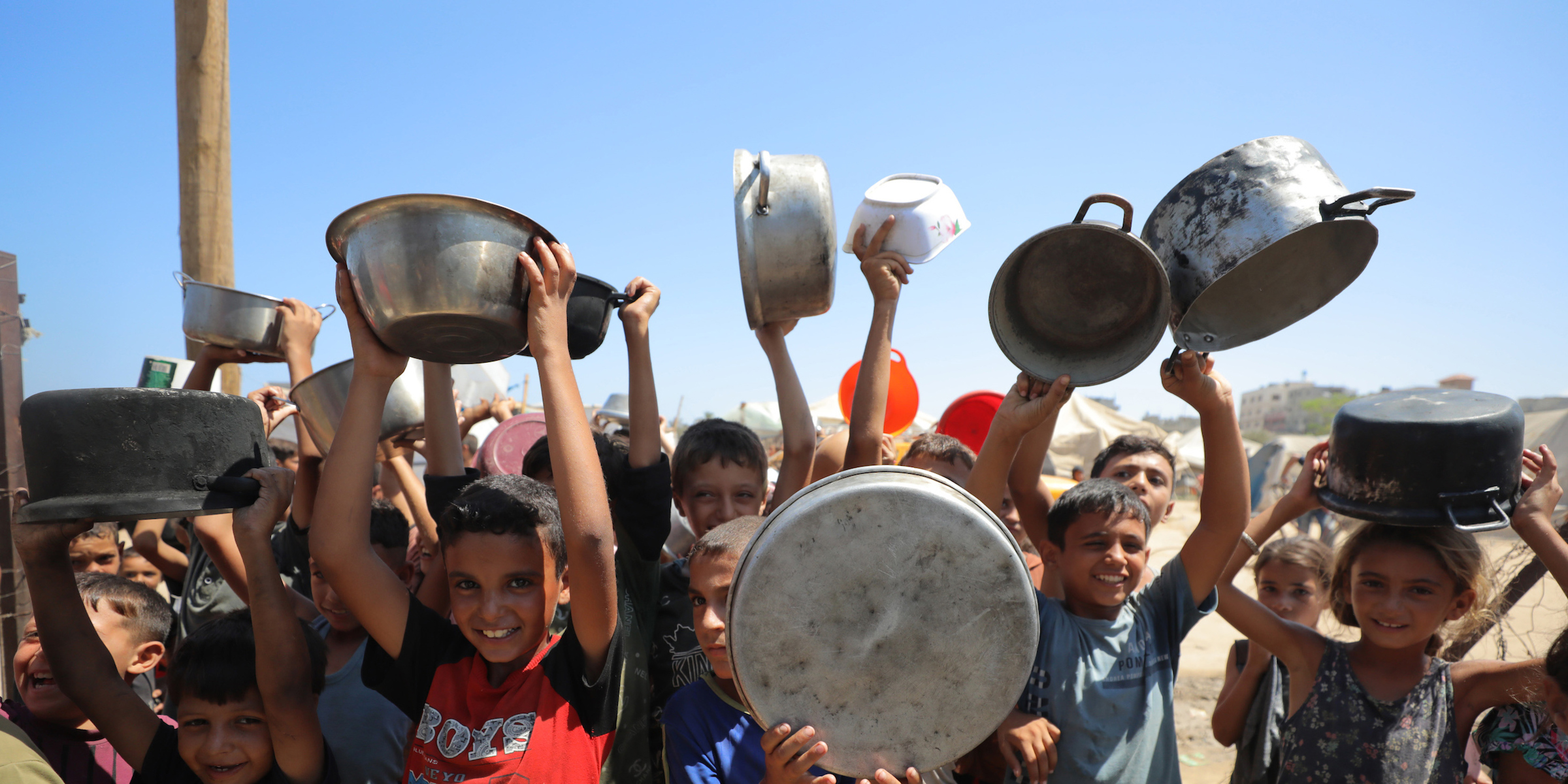 children holding pans for food