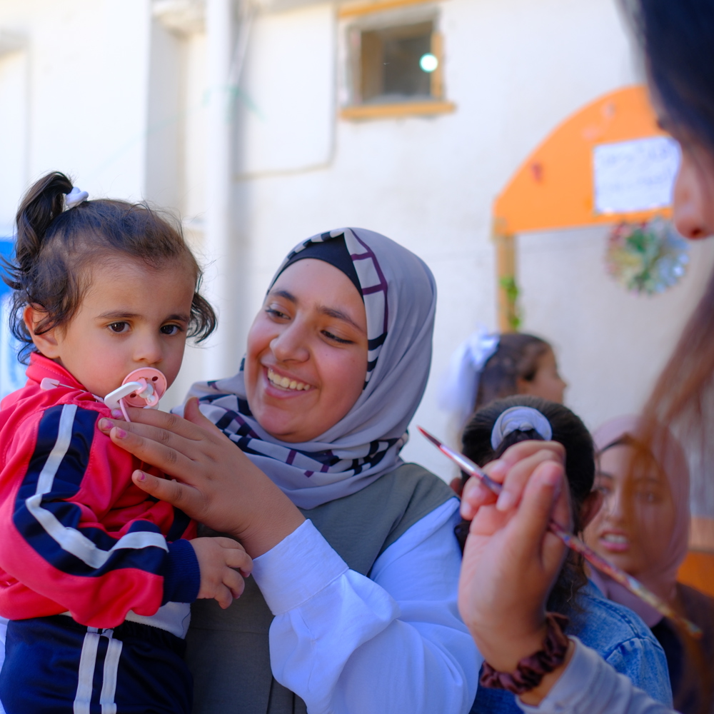 holding a baby and smiling