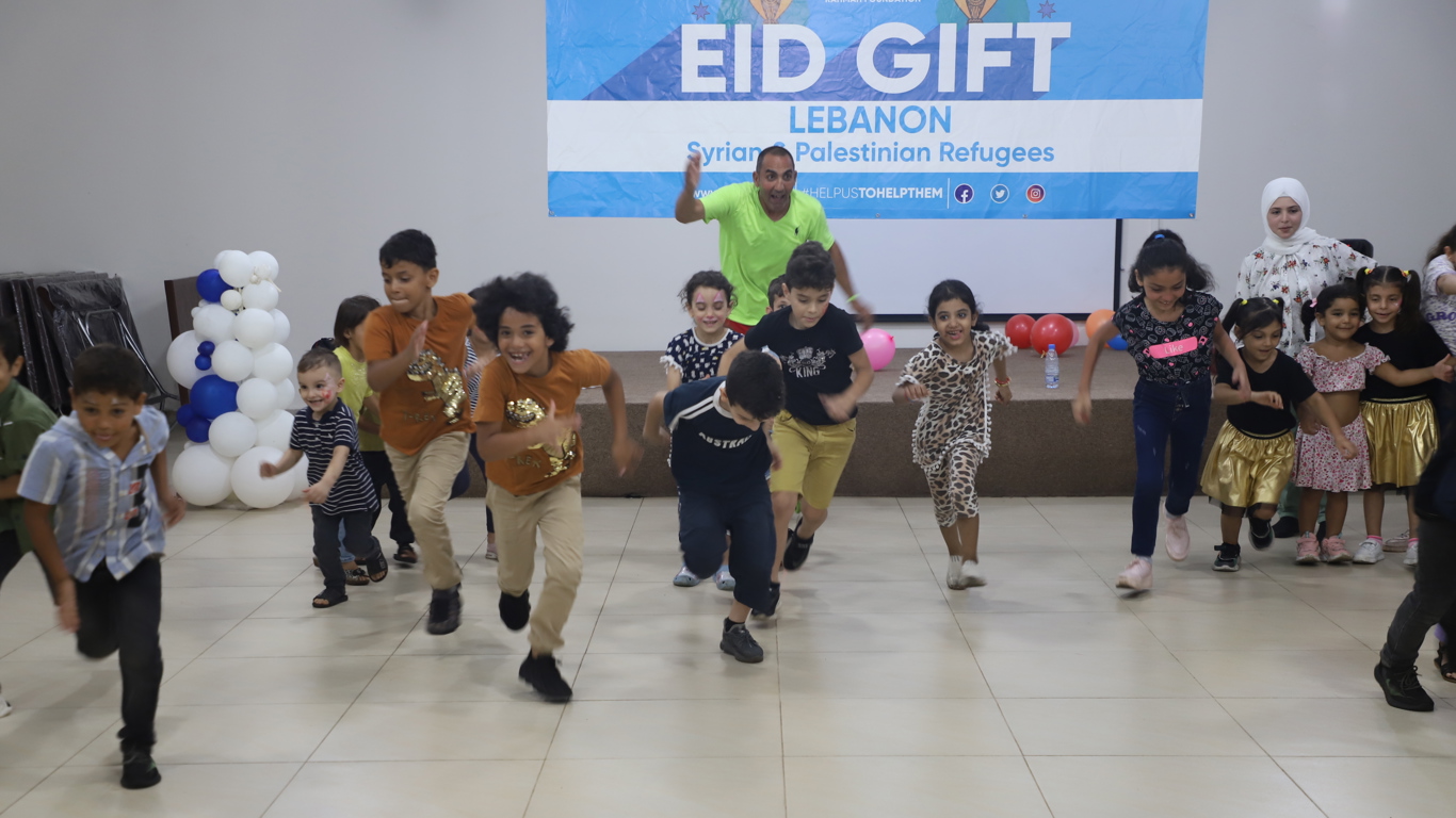 Refugee children laughing and happily playing with representative of Global Rahmah Foundation in Lebanon