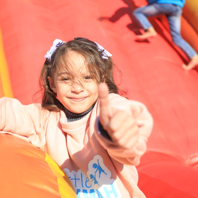 Gaza orphan sponsorship 2023 - young child smiling and holding thumb up