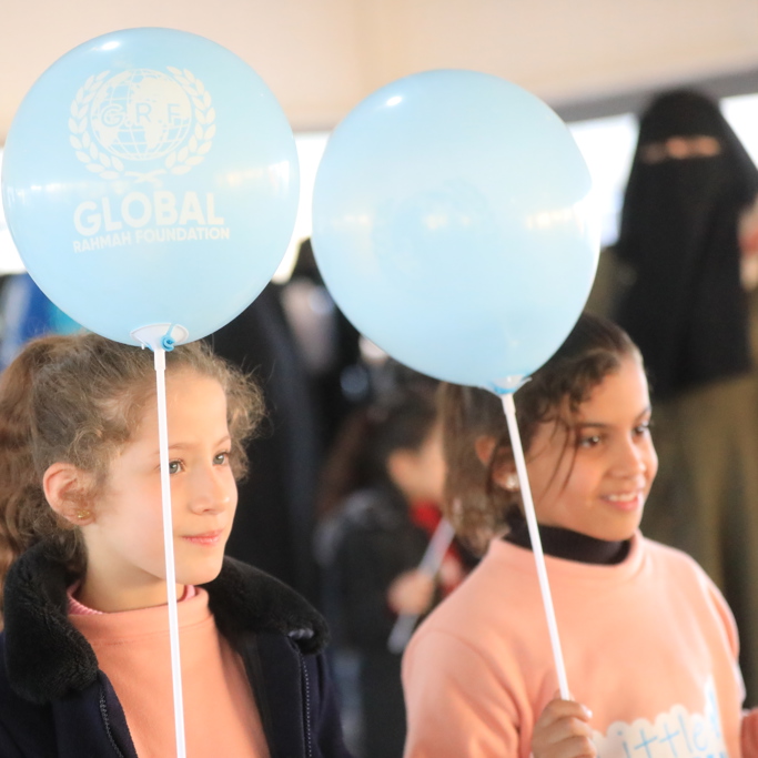 young orphan children in Gaza holding balloons and smiling 2023