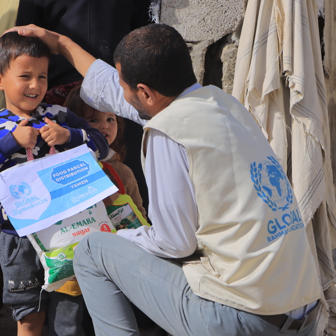 GRF delivering food aid in Yemen to young child