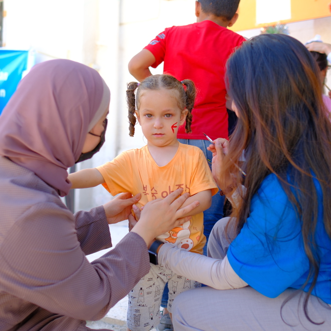 GRF staff painting a child's face in Jordan