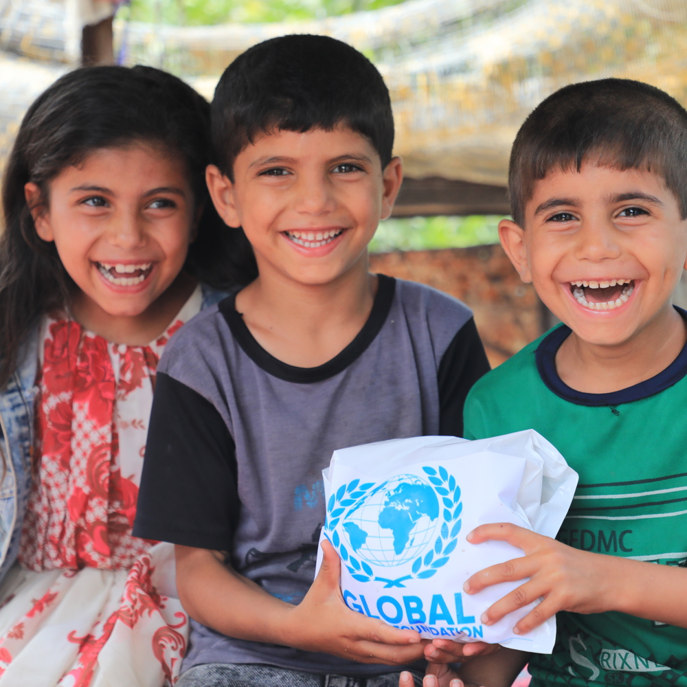 children smiling holding Qurbani meat from GRF