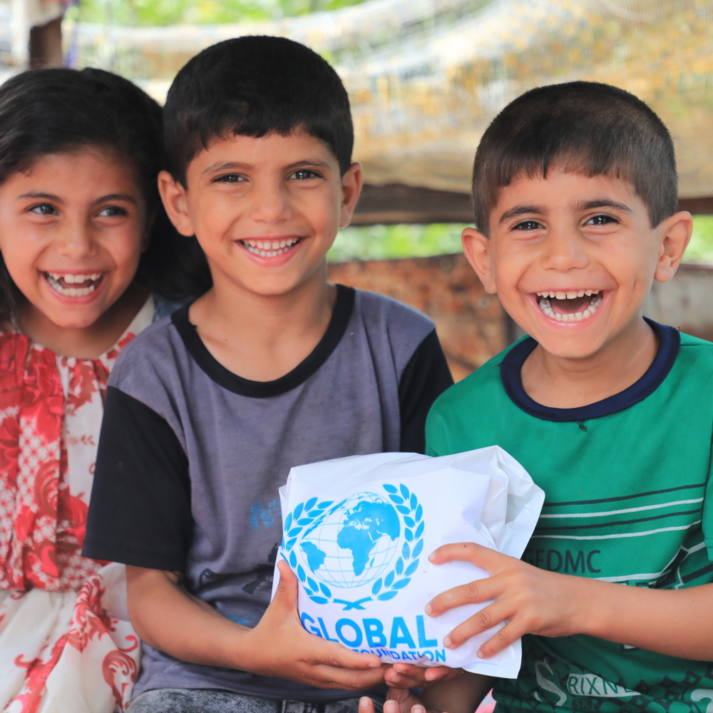 children smiling holding Qurbani meat from GRF