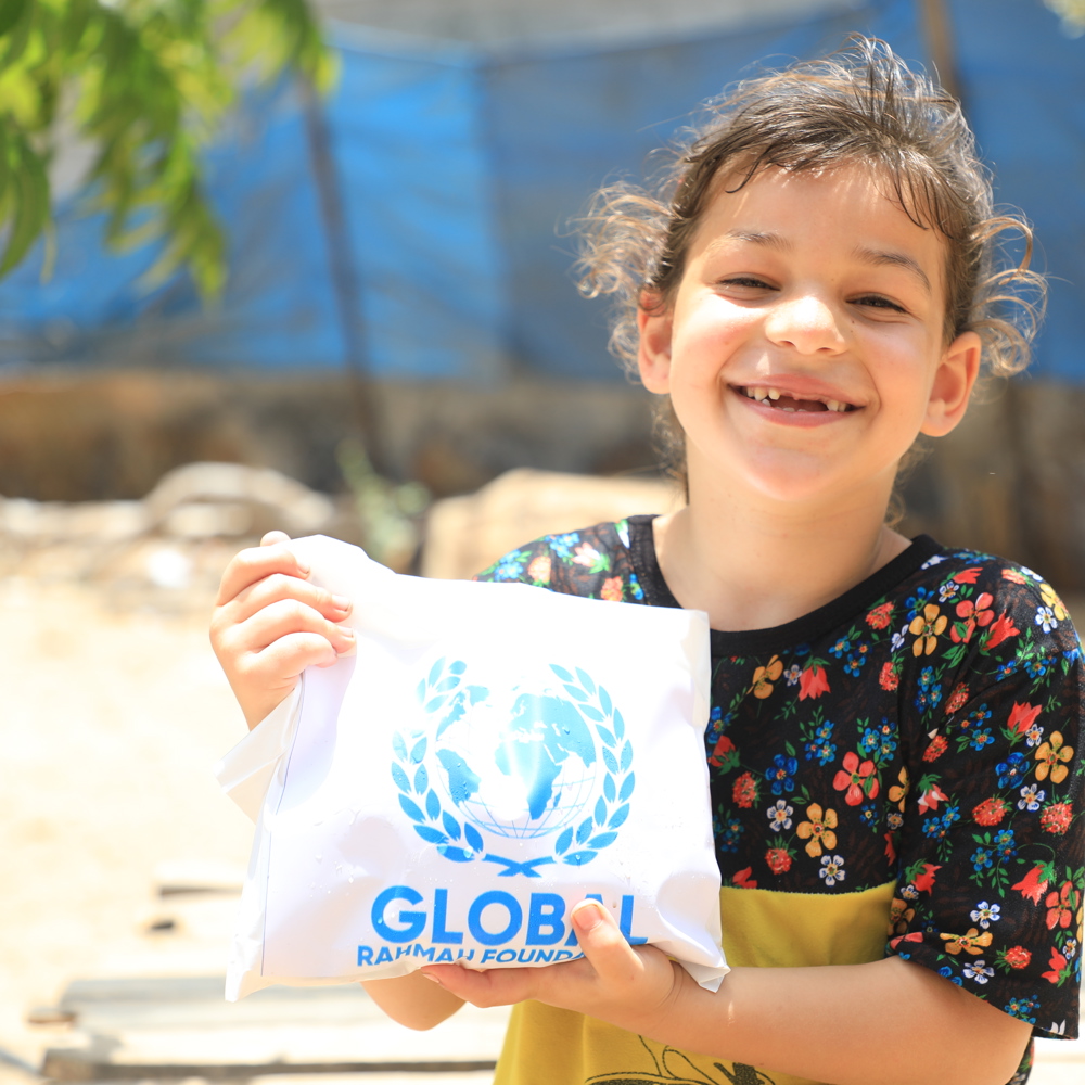 child holding Qurbani meat smiling
