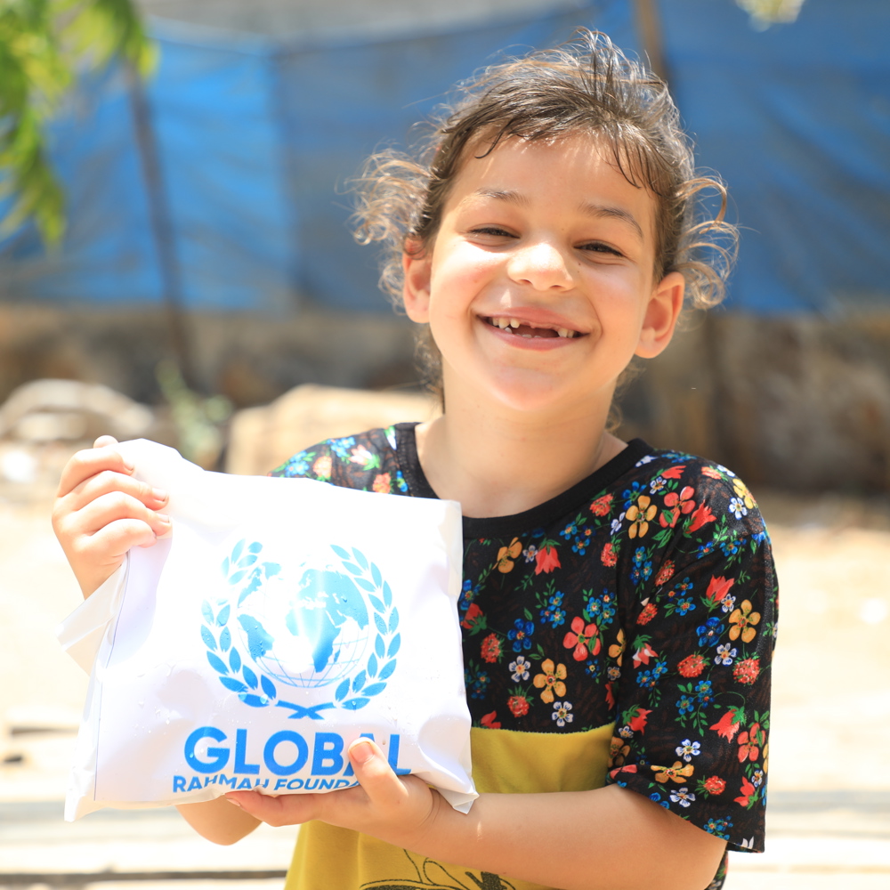 child holding Qurbani meat smiling